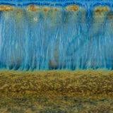 closeup of an amber blue glaze on a medium square ceramic plate