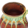 close up of a round tea mug showing orange red color with green ash glaze drips