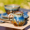 brown and blue handmade stoneware mug as part of a dinnerware set on a table outside