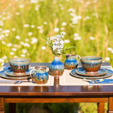 spring outdoors table setting, including a ceramic bud vase, stoneware mugs, dinner plates, lunch plates, and cereal bowls