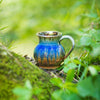 amber blue small handmade coffee mug outdoors at spring